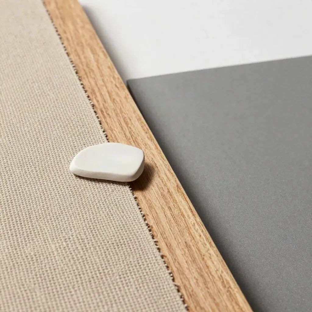 Makro eines Möbelplans mit Leinenmuster, hellem Holz und Keramikfragment im Studio.